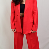 Model wearing a red blazer with red pants