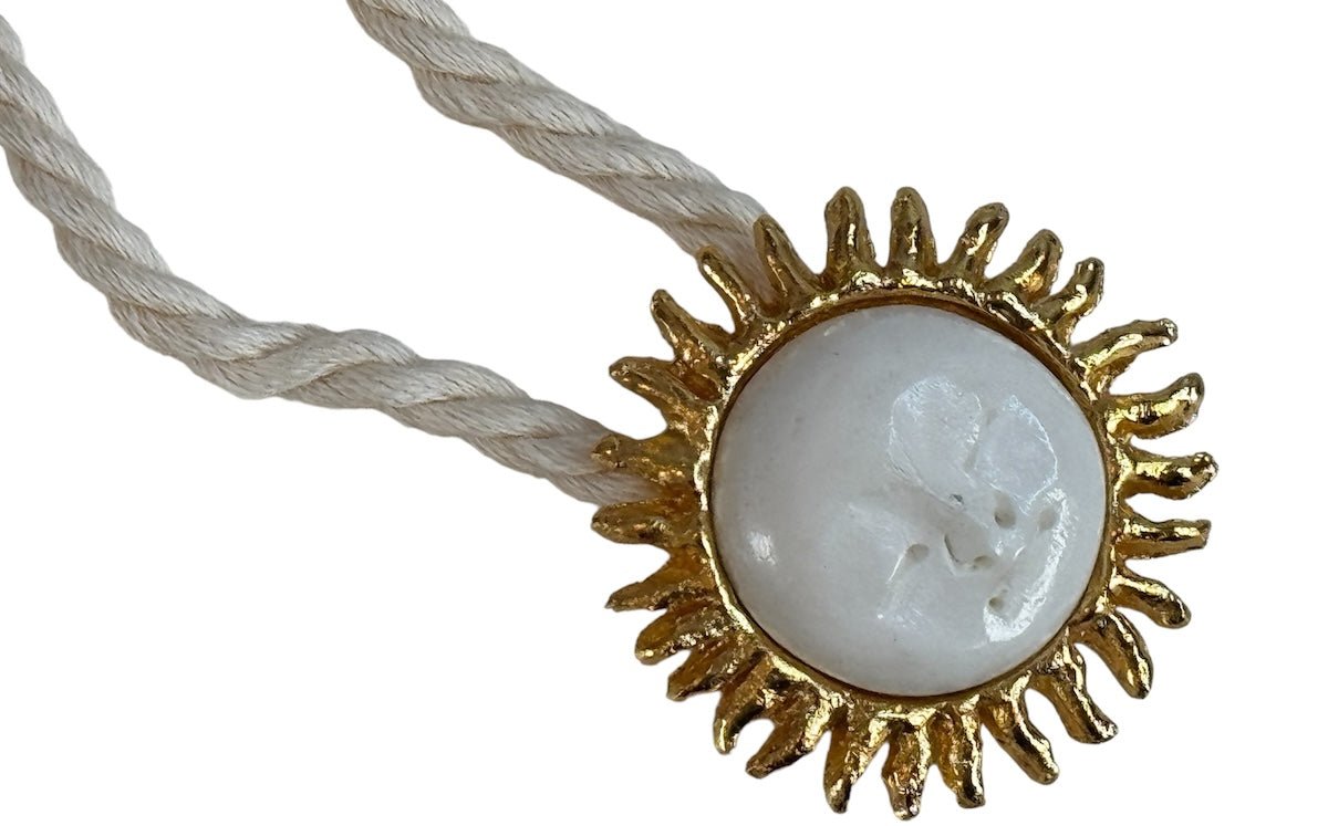 Image of a cord necklace with a sun charm. it's against a white background. the purpose of this image is to highlight the necklace by Pajarolimon jewelry because it's for sale at EVAMAIA Boutique in Studio City, CA.