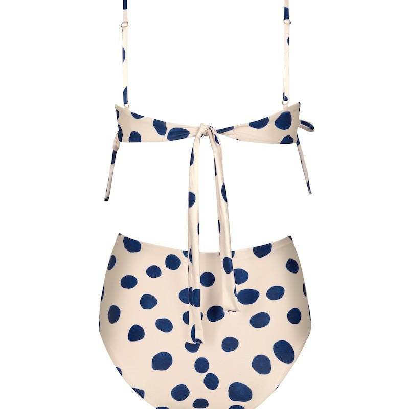 Back of a white swimsuit set with blue polka dots. It's on a white background. The purpose of this image is to highlight the swimsuit because it's for sale at EVAMAIA Boutique.