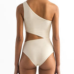 Back of a model wearing the Diana One Piece swimsuit by Encantadore Swimwear. It has a cutout on the waist and and elegant one-shoulder look.