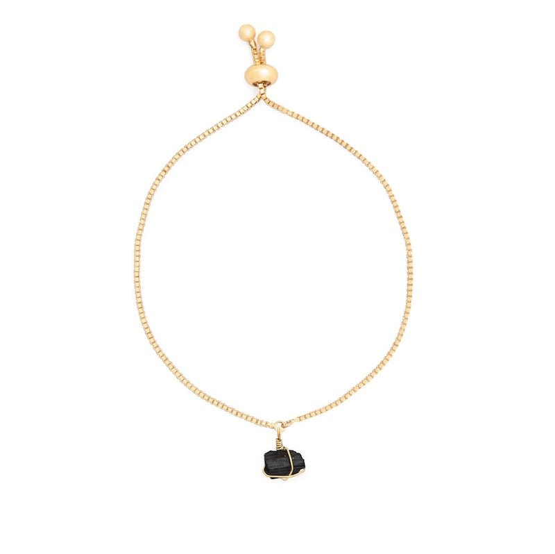 Image of a gold chain bracelet with a black tourmaline stone on it.The purpose of the image is to highlight the bracelet because it is on sale at EVAMAIA boutique in Studio City, CA.