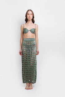 Model wearing a laser cut green skirt by Mar de Lua. She's standing in front of a white background. The purpose of the image is to highlight the skirt because it's for sale at EVAMAIA boutique in Studio City, CA.