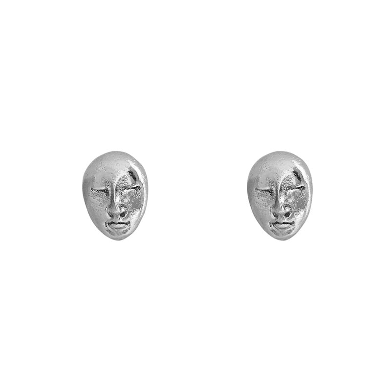 Image of a set of stud earrings of a face in Silver. It's set against a white background. The purpose of this image is to highlight the earrings by Pajarolimon Jewelry.