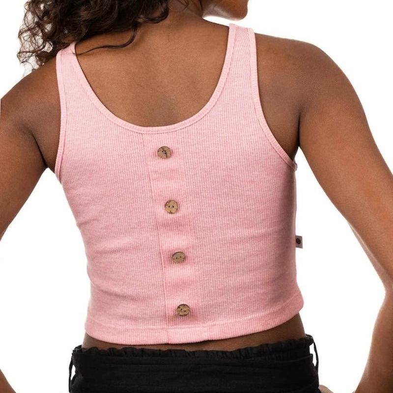 Back of a woman wearing a pink ribbed top and black bottoms. She's standing by a white background and looking at the camera. The purpose of this image is to highlight the sustainable clothing by Madre Tierra.