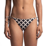 Close up of the back of a woman wearing a black and white bikini bottom. She's in front of a white background. The purpose of this image is to highlight the bikini, which is available for sale at EVAMAIA Boutique in Studio City, CA.